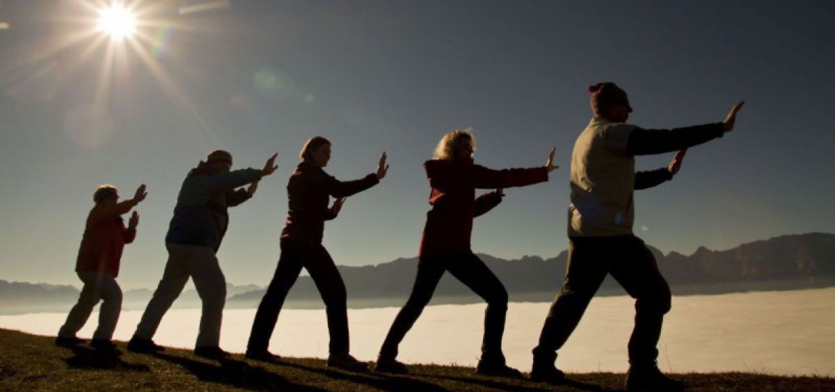 Gruppe macht Tai Chi - Übungen am Berg