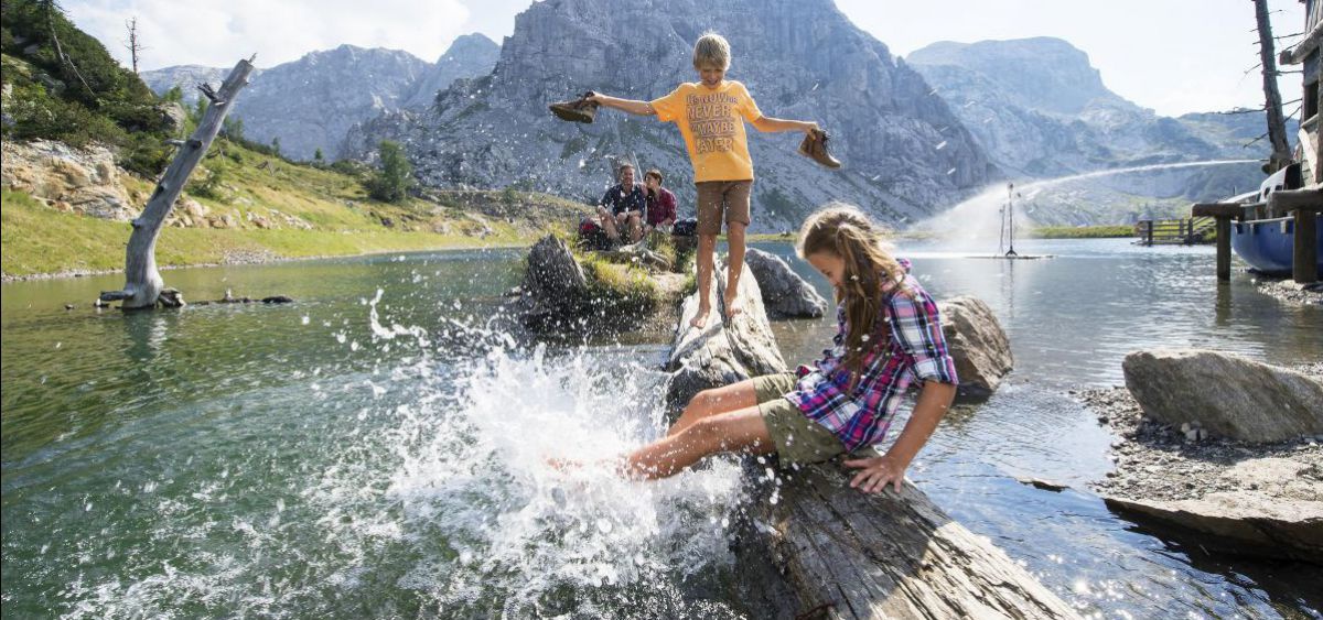 Kinder plantschen mit dem Bergwasser