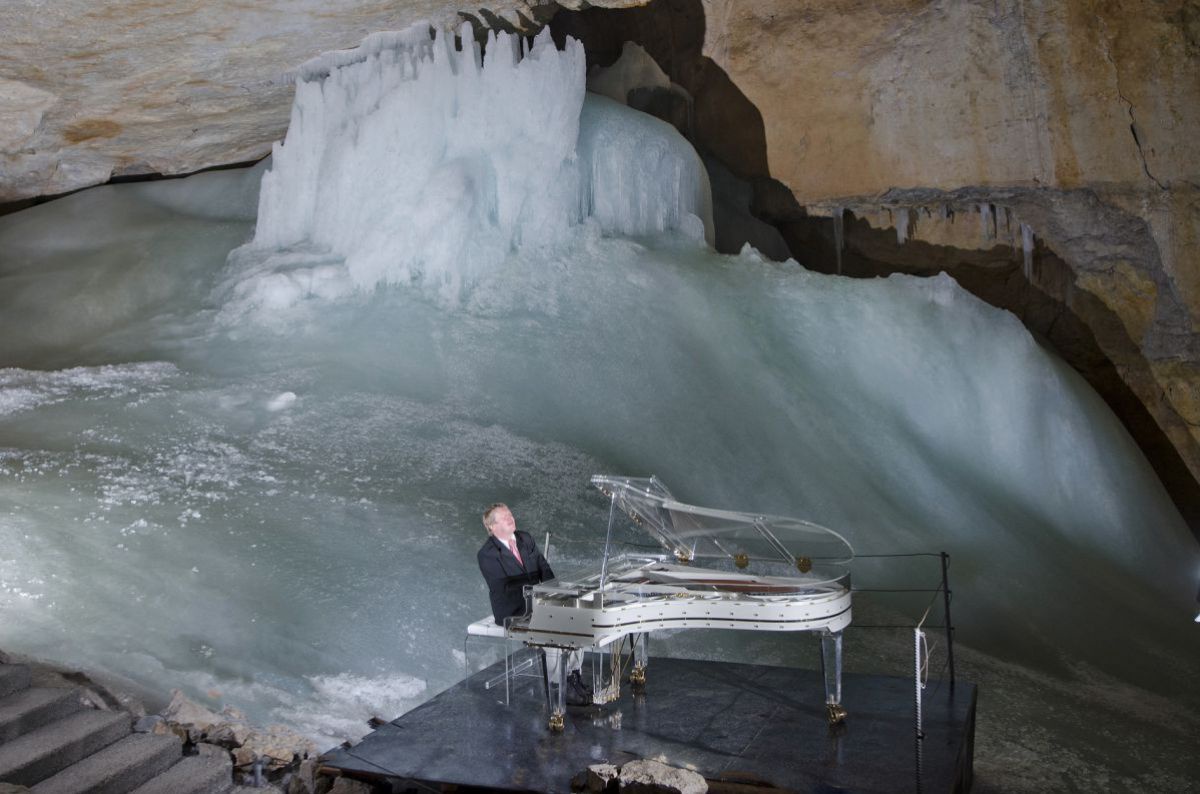 Pianist auf Flügel in der Eishöhle
