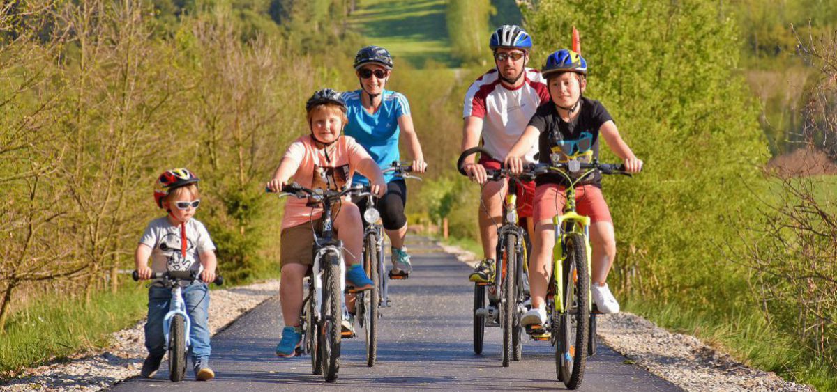 Familie mit dem Fahrrad auf aufgelassenen Bahntrassen unterwegs.