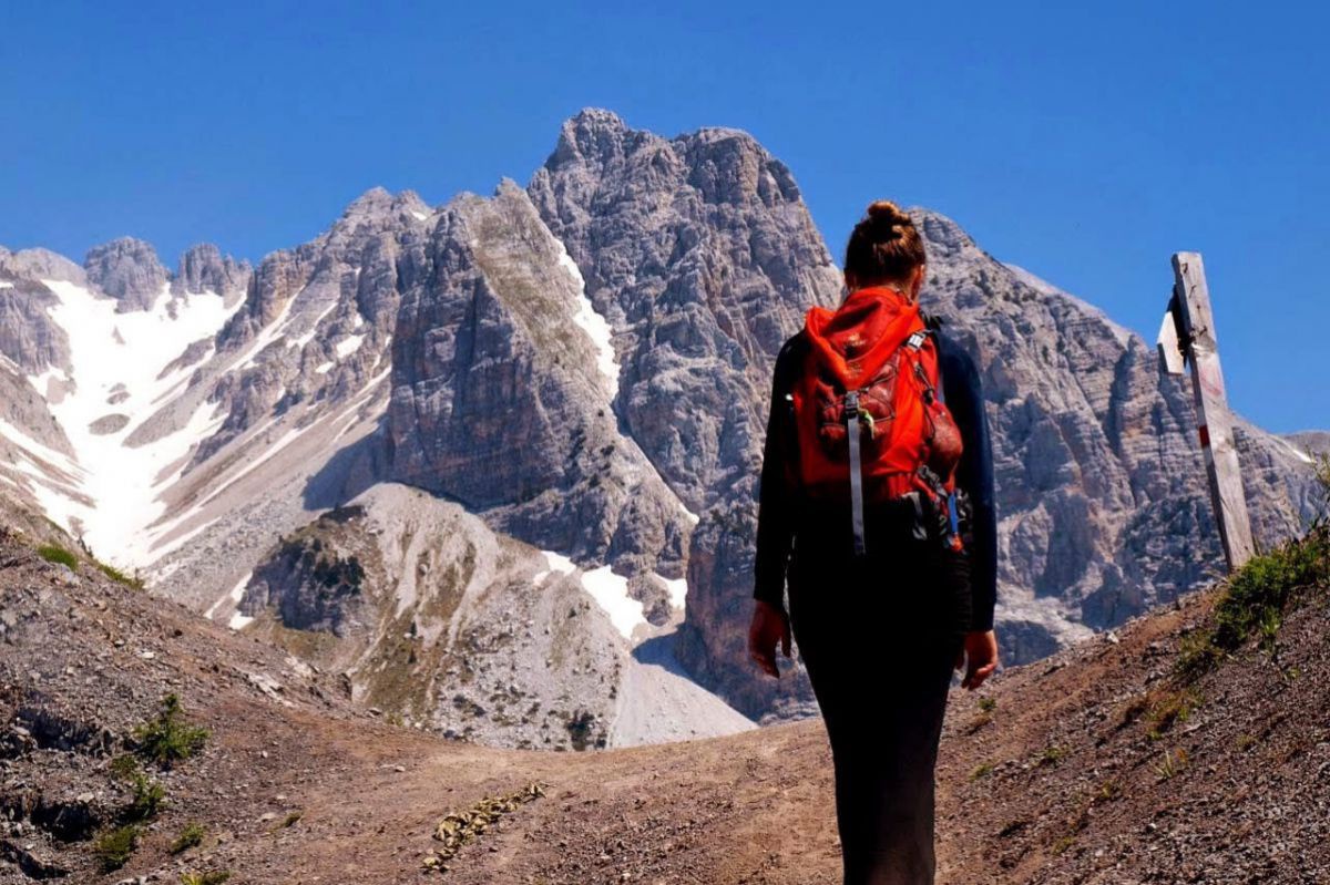 Frau wandert, Hintergrund Berggipfel