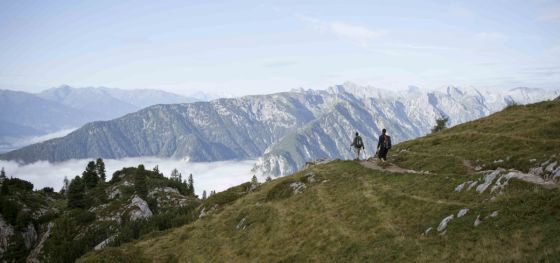 2 Wanderer in der weiten Bergwelt, im Tal liegt der Nebel.