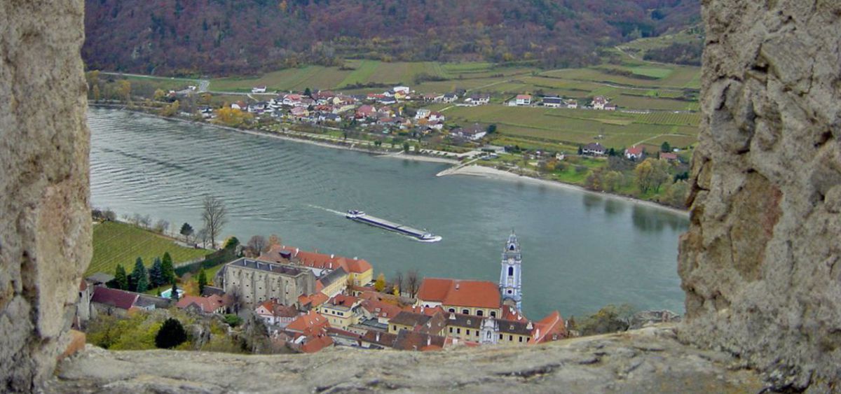 Blick von der Ruine auf Dürnstein und die Donau, auf der gerade ein Schiff fährt.
