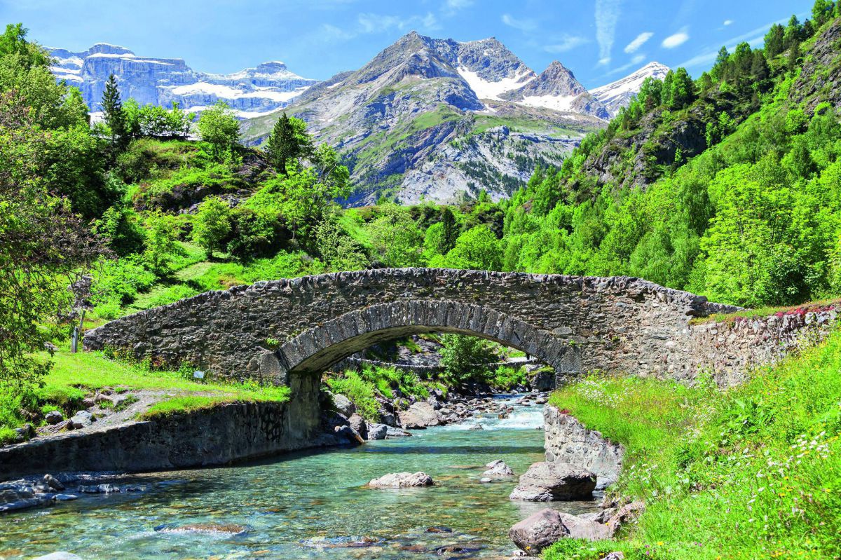 Steinbrücke über Fluss im Gebirge.