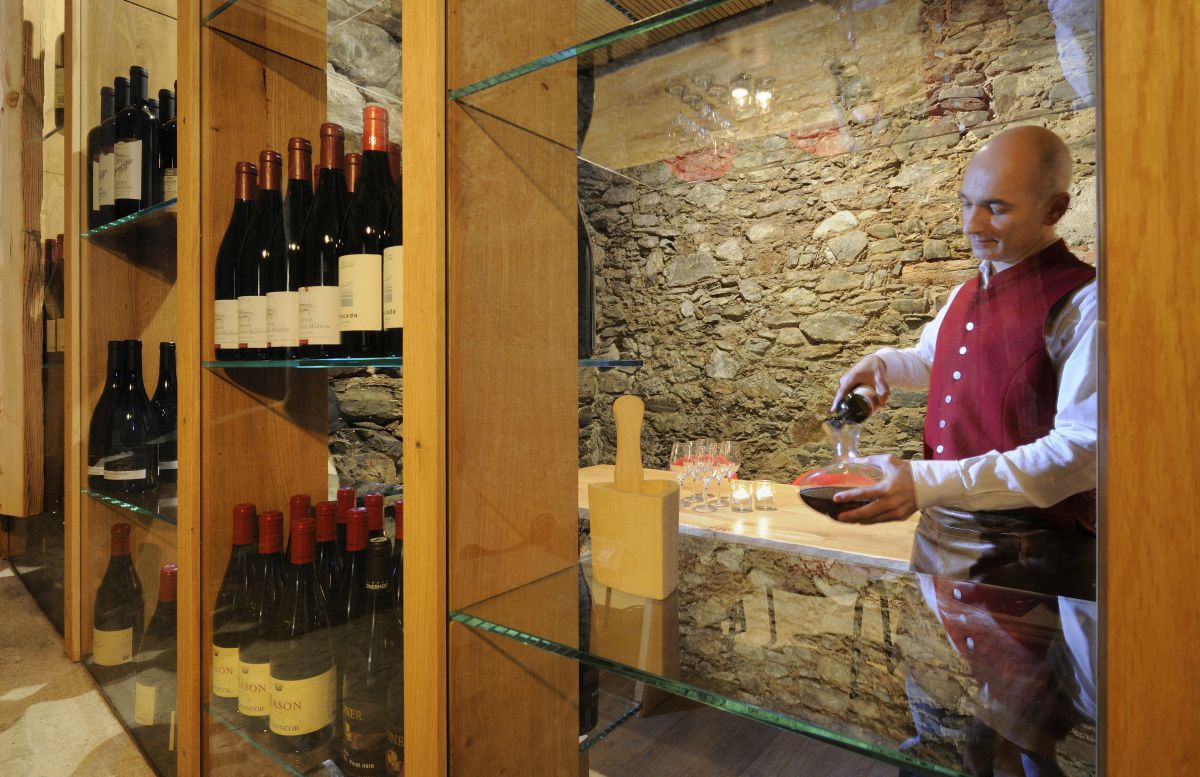 Hausherr Stephan Kofler dekandiert im Weinkeller einen Rotwein.im Weinkeller