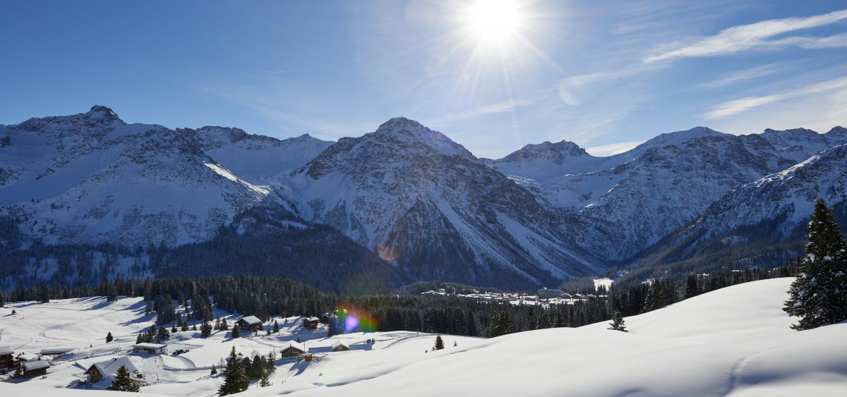 Schneebedeckte Lanschaft im Sonnenlicht.