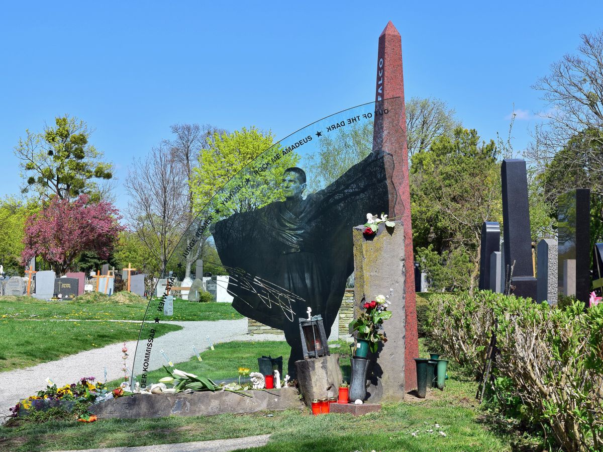 Grab von Falko - halbrunde Glasscheibe mit seinem Abbild mit Obelisk