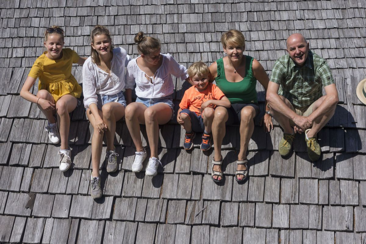 Maria und Franz Hinteregger mit vier Kindern auf einem Schindeldach.