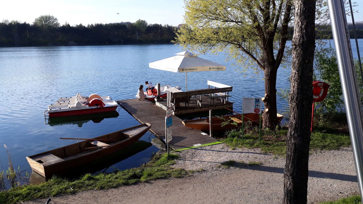 Bootsanlegestelle mit Ruder- und Tretbooten am See.