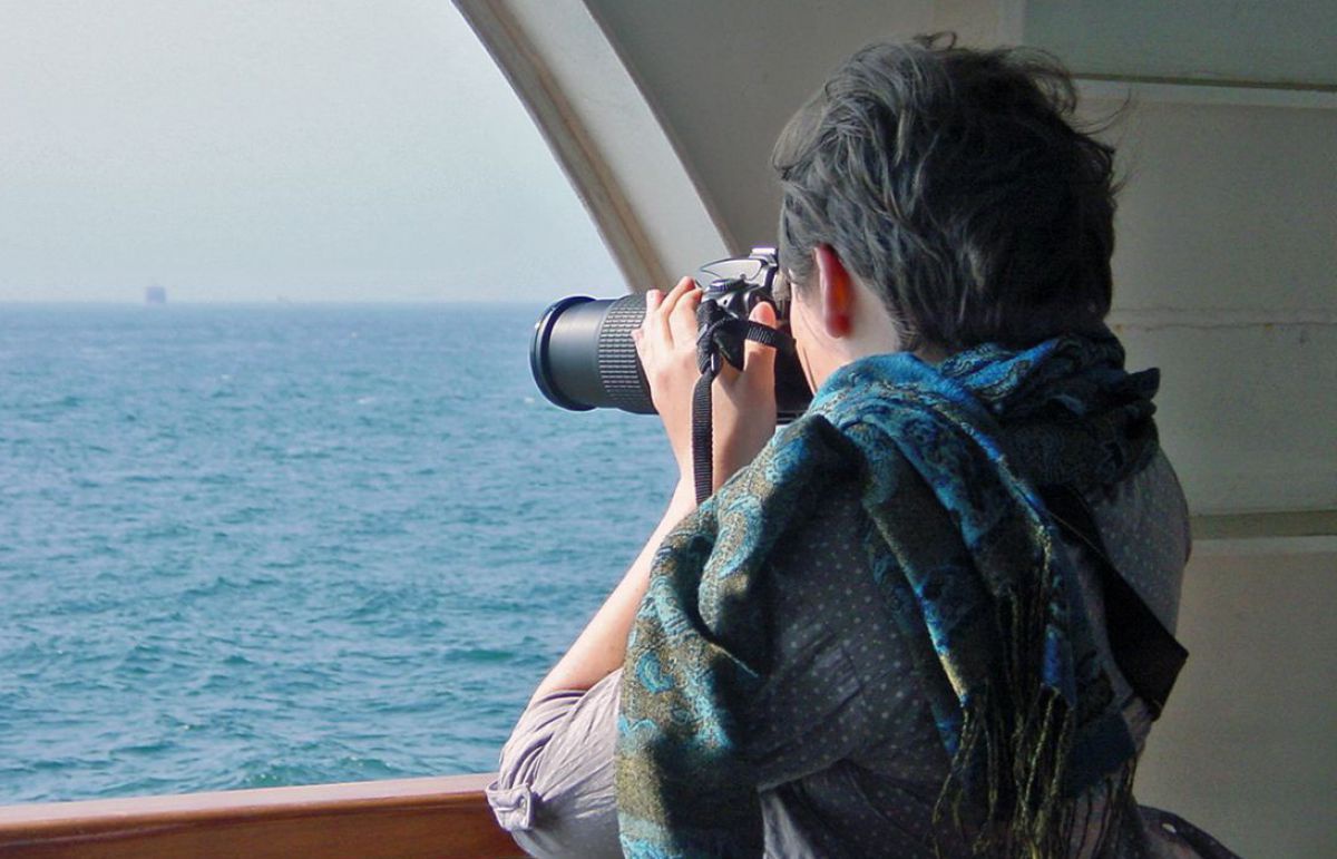Frau fotografiert von einem Schiff aus auf das Meer.