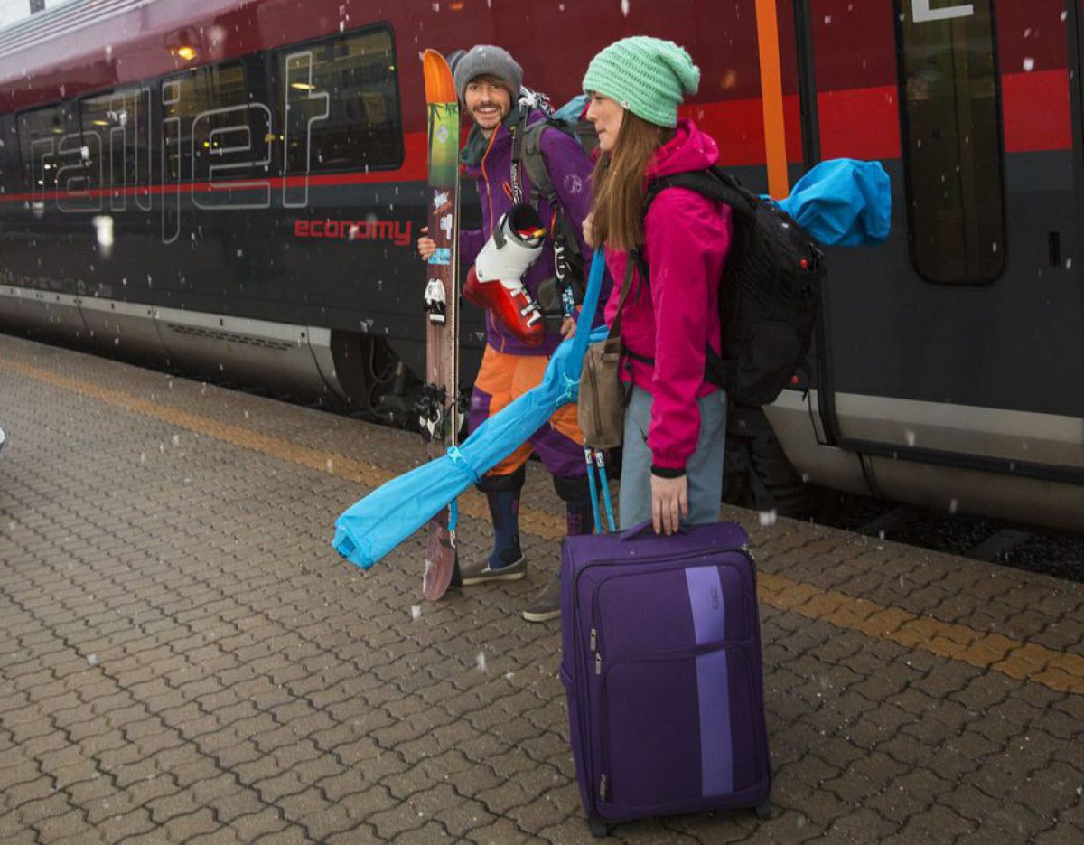Paar mit Gepäck am Bahnsteig