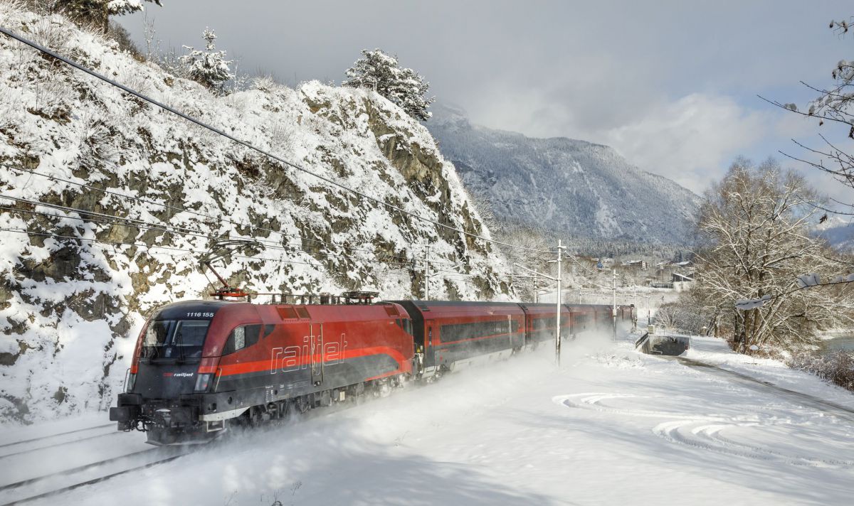Zug fährt durch Winterlandschaft.