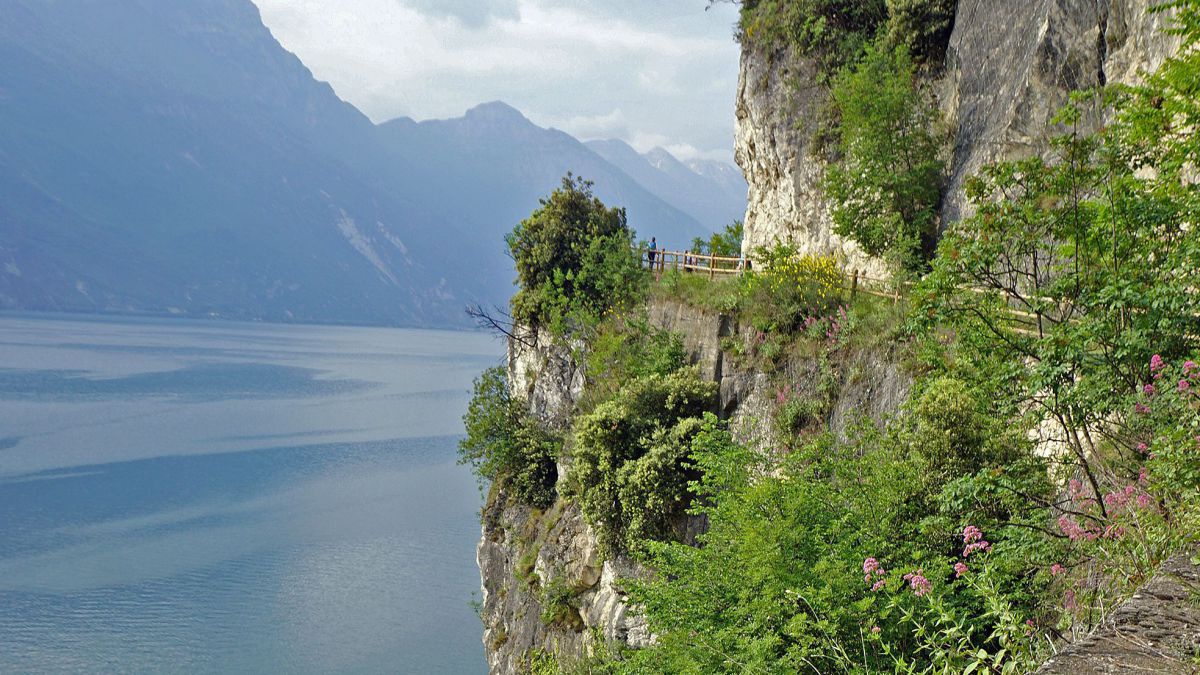 Weg entlang eines Felshanges hoch über einem See.