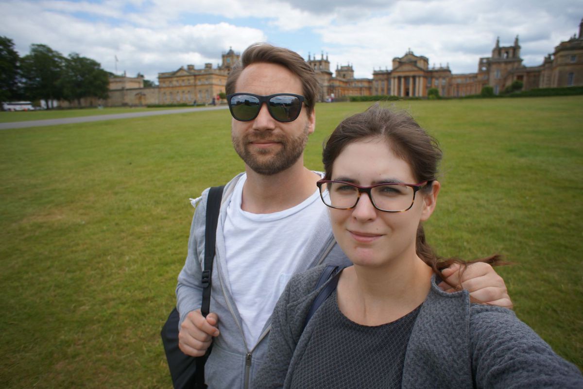 Mann und Frau vor altem englischem Gebäude.