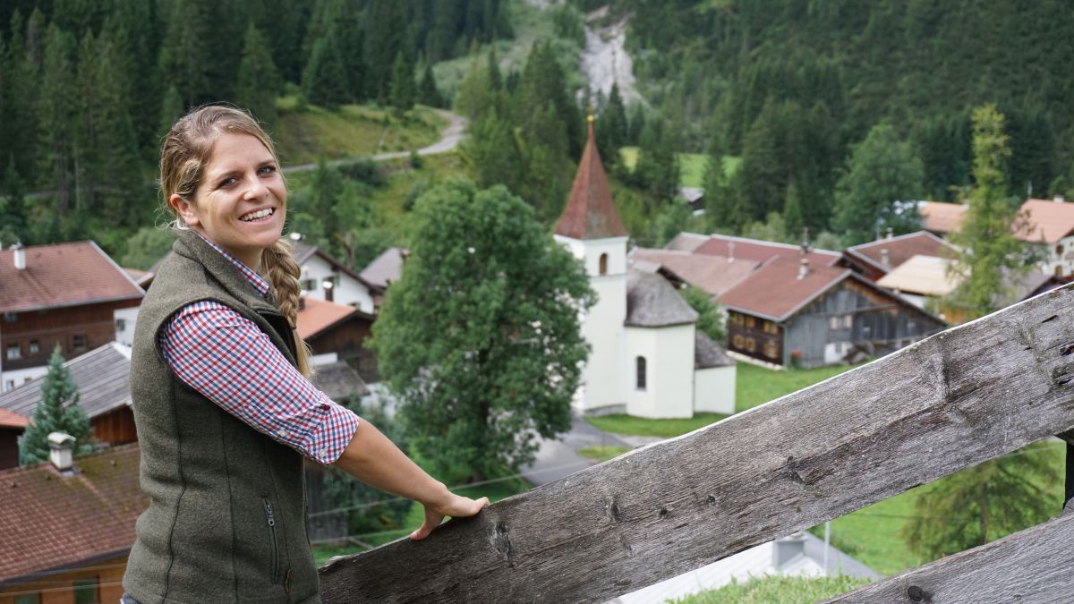Ramona Sprenger mit Blick hinunter auf ein Dorf - im Zentrum eine Kirche.