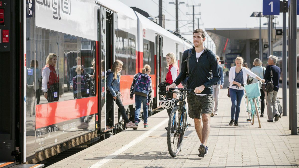 Radfahrer schieb sein Rad am Bahnsteig.