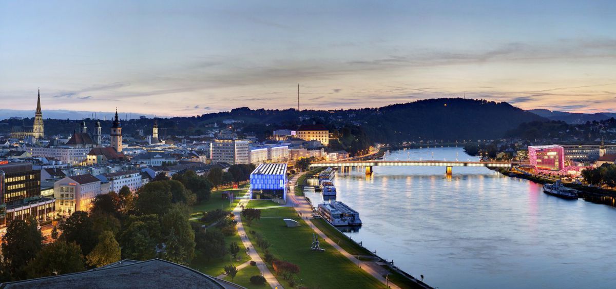 Abendlicher Panoramablick über Linz, in der Mitte die Donau.