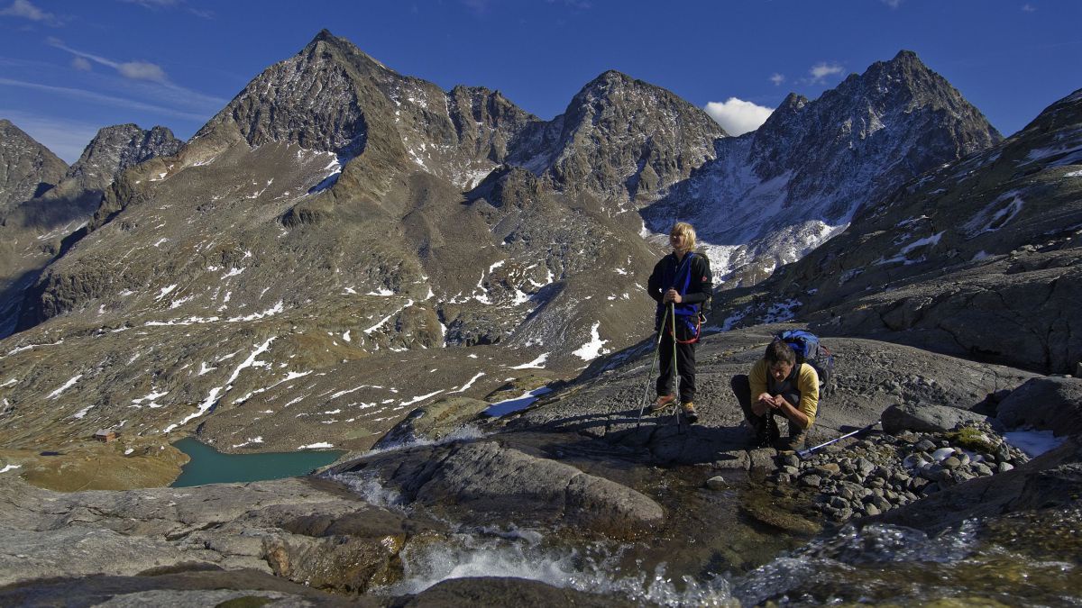 2 Wanderer in schroffer Hochgebirgslandschaft.