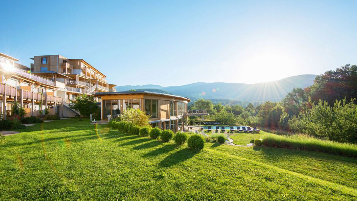 Retter Bio Natur Resort von Außen mit Blick auf Pool und Liegewiese bei Sonnenaufgang.
