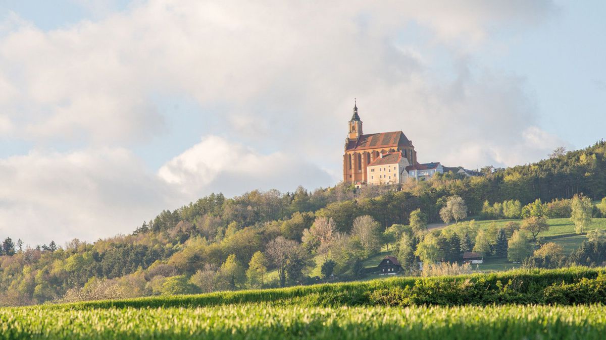 Freistehende Kirche auf einem Hügelrücken.