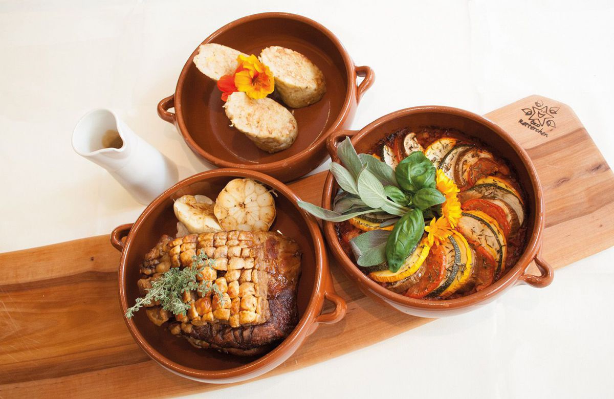 Schweinsbraten, Ratatouille, Apfelsemmelknoedel - jeweils in einer Schüssel.