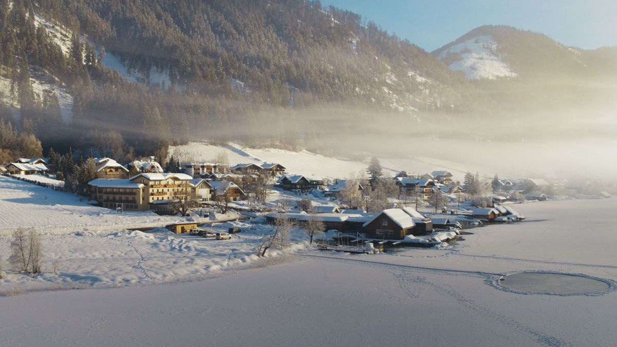 Strandhotel Weissesee im Winter im Schnee mit zugefrorenem Seeinter.