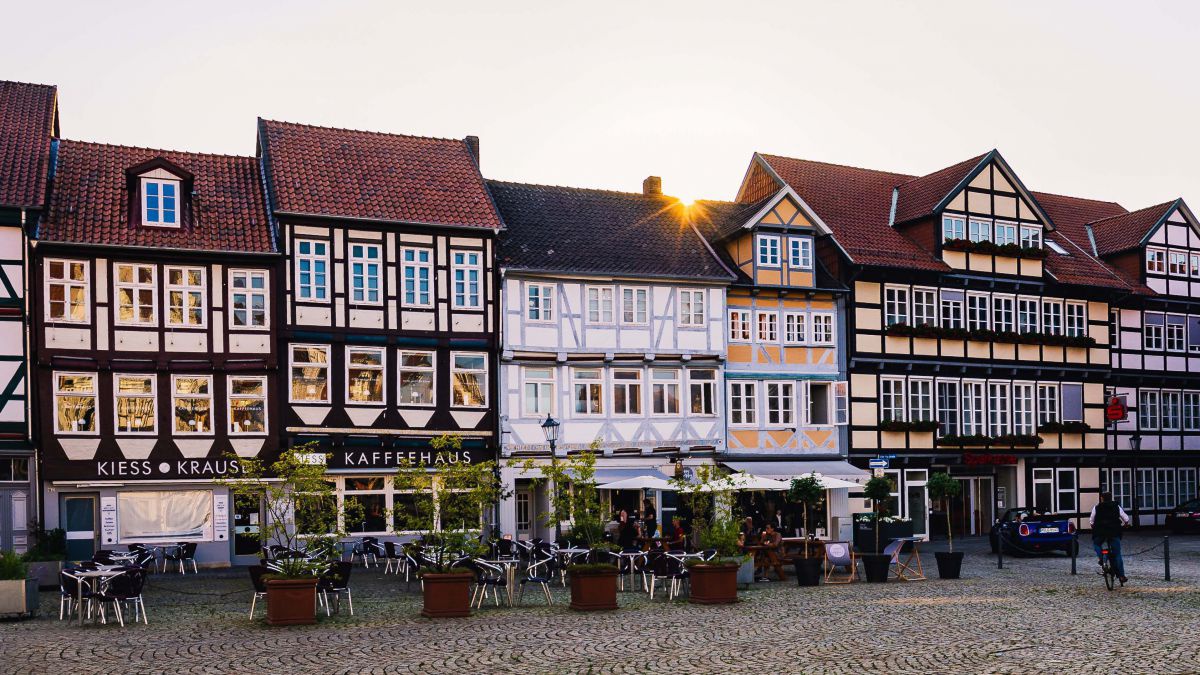 Gepflasterter Platz mit Schanigärten vor Fachwerkhäusern.