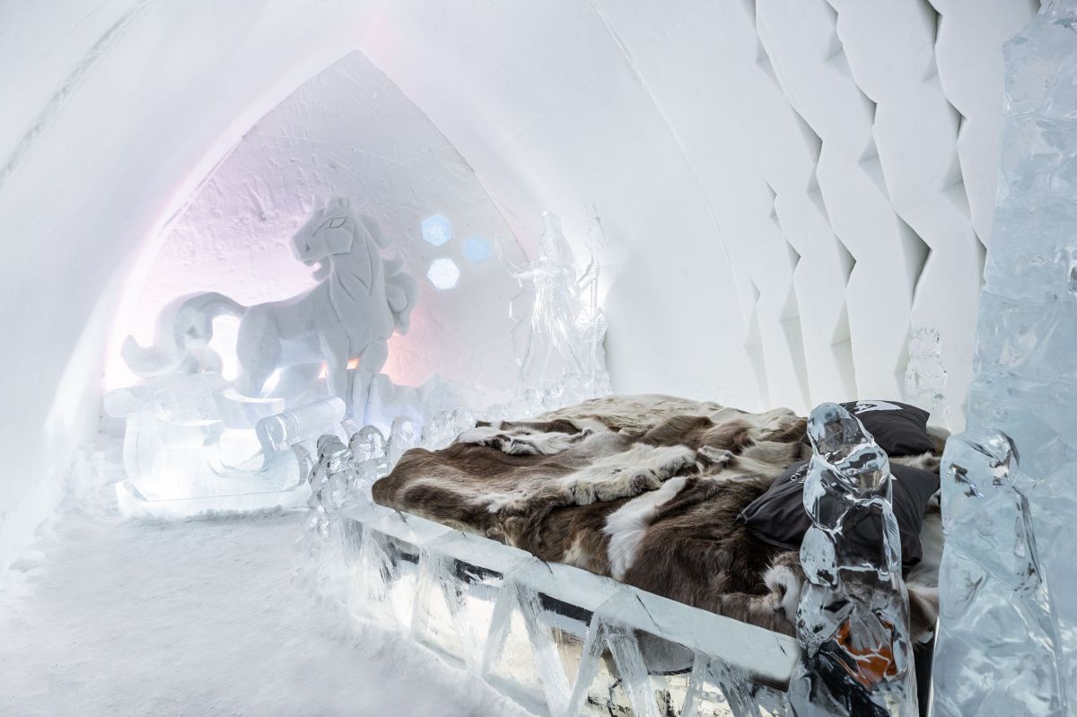Raum aus Eis, in der Wans eine Figur aus Eis geschnitzt, Doppelbett aus eis, darauf Rentierfelle.