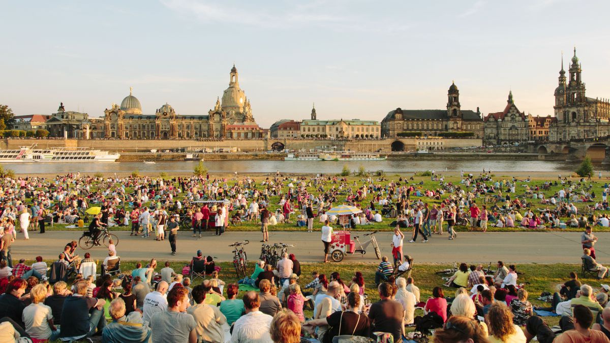 Tausende Leute sitzen in den Wiesen an der Elbe oder flanieren herum.
