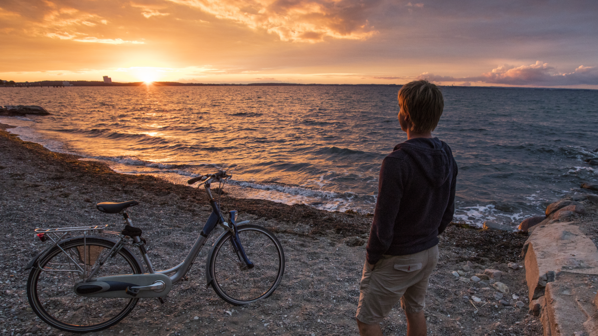 Radfahrer bei einer Rast am Strand bei Sonnenuntergang.