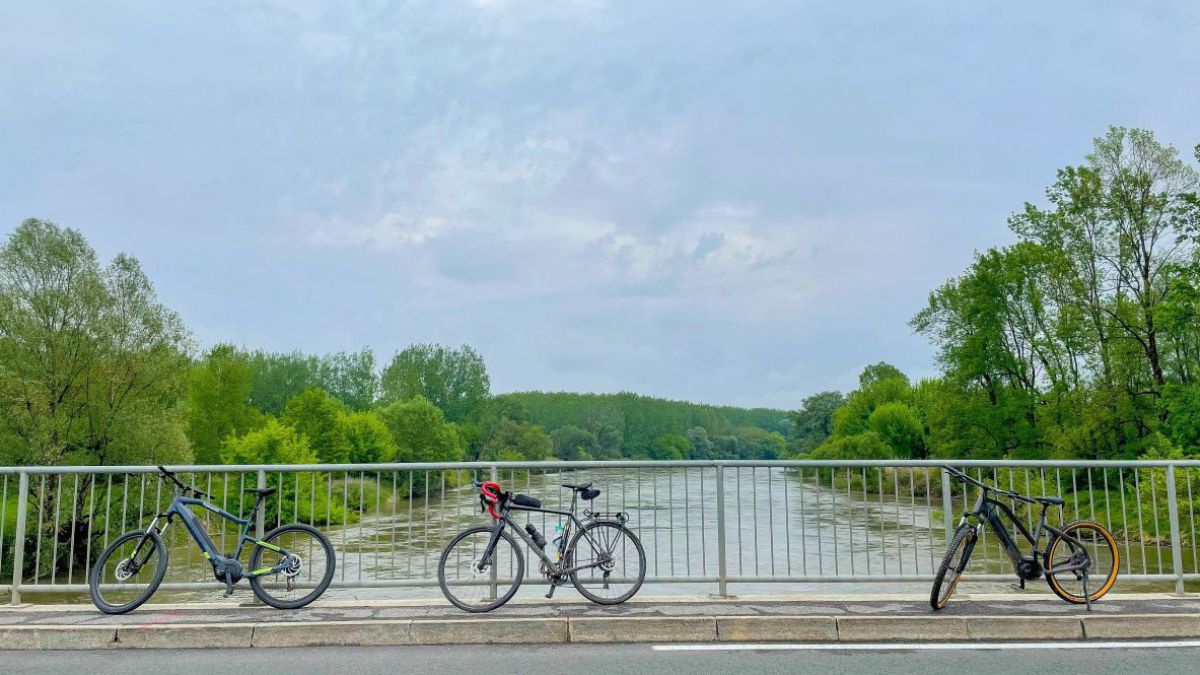 Drei Fahrräder lehnen am Geländer einer Brücke über der Mur in Slowenien.