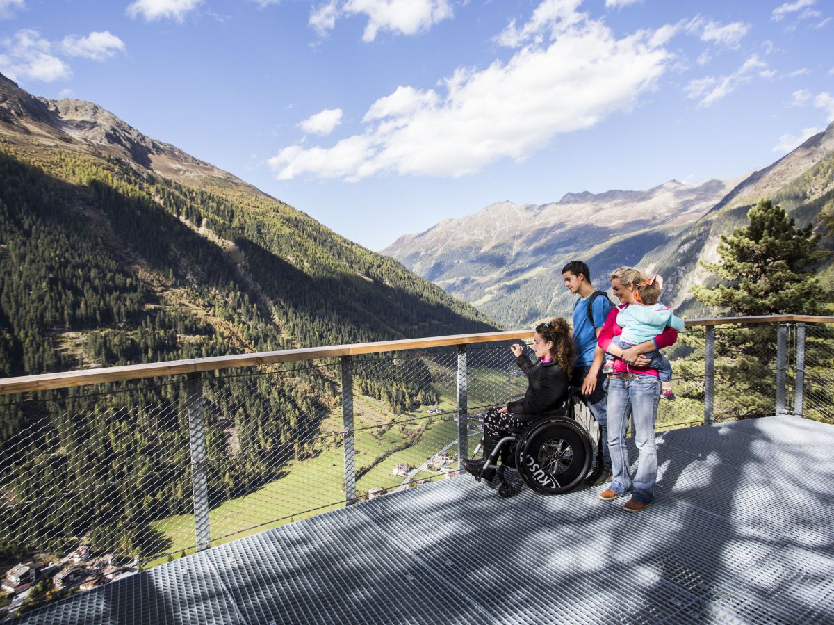 Eine Familie genießt den Ausblick auf das Bergpanorama von der Aussichtsplattform 
