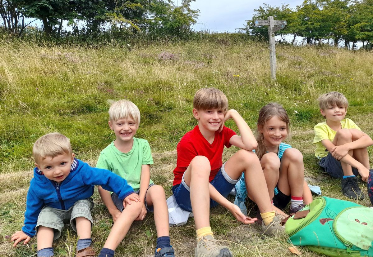 Die fünf Kinder von Stefan und Sandra Lobnig sitzen während der Wanderung im Gras