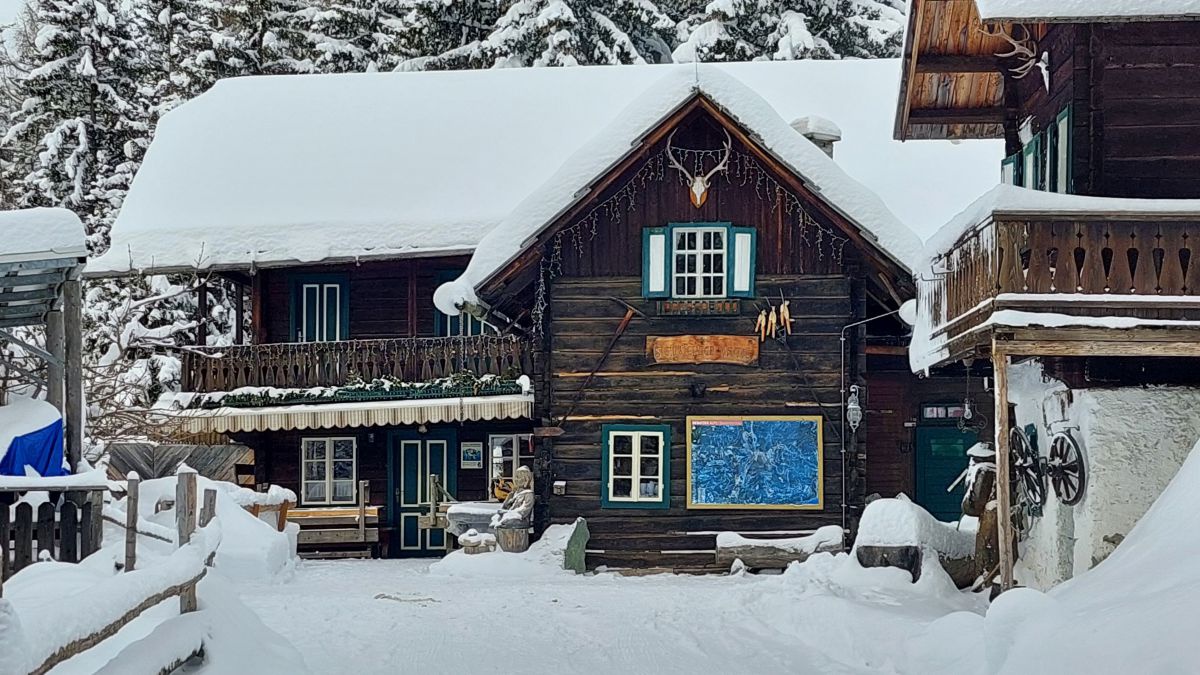 Steinwenderhuette - Holzhütte aus dunklem Holz mit jeder Menge Schnee.