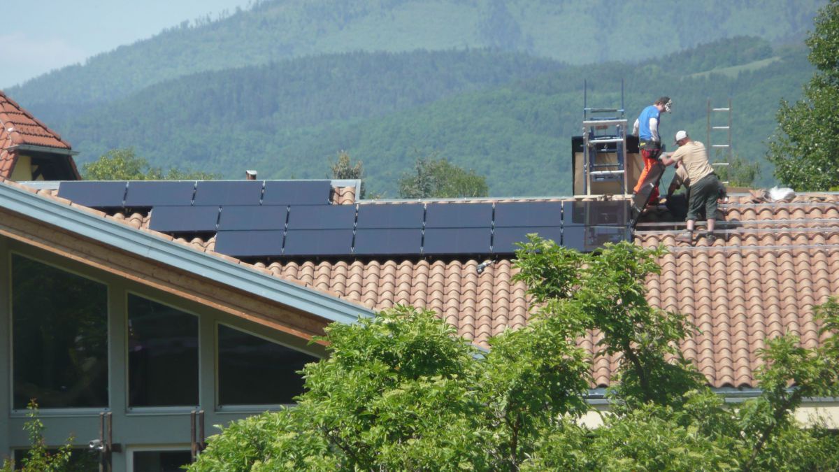 2 Männer auf dem Dach bei der Montage von PV-Modulen