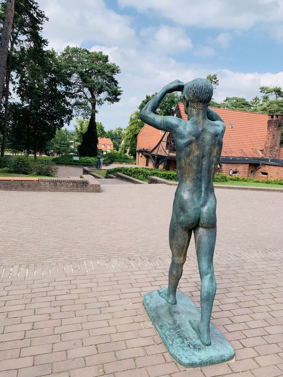 Bronzestatue eines schreitenden Menschen auf einem Platz im Künstlerdorf Worpswede.
