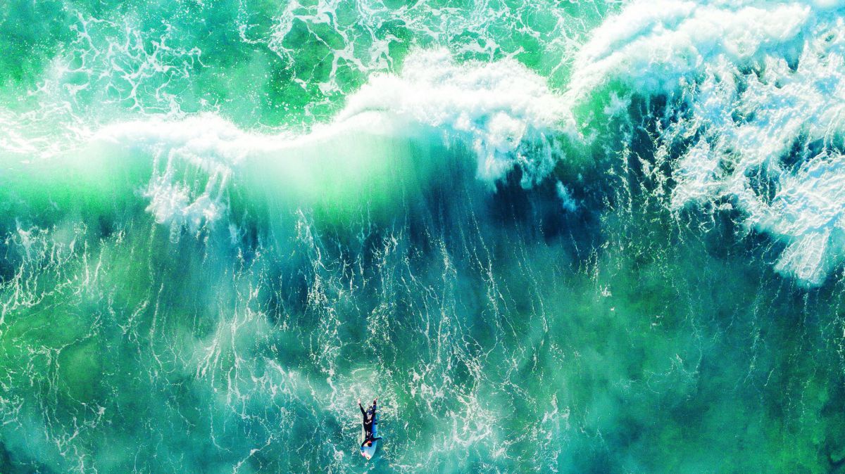 Surfer auf dem Meer, von hoch oben fotografiert.
