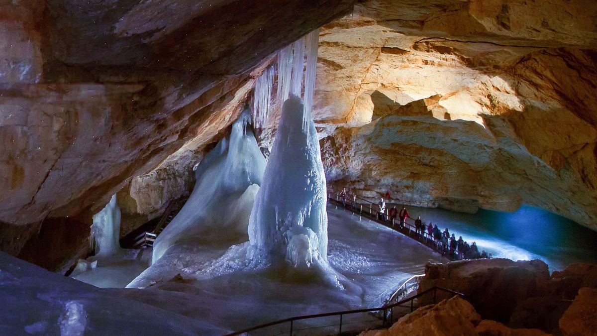 Blick in die Rieseneishöhle im Dachsteingebirge im Salzkammergut: Eisformationen zwischen Felsspalten durch die befestigte Steige für die Besucher*innen führen.