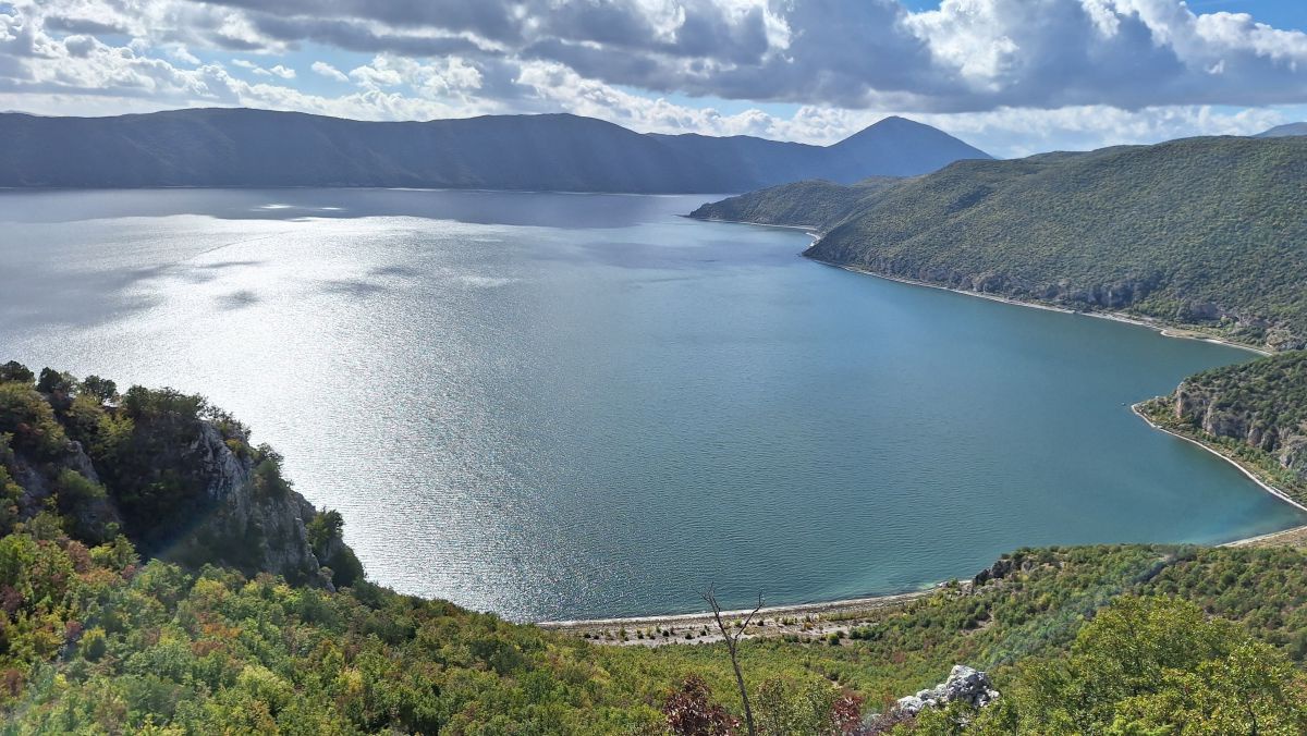 Blick auf einen See, rundherum viel Wald.