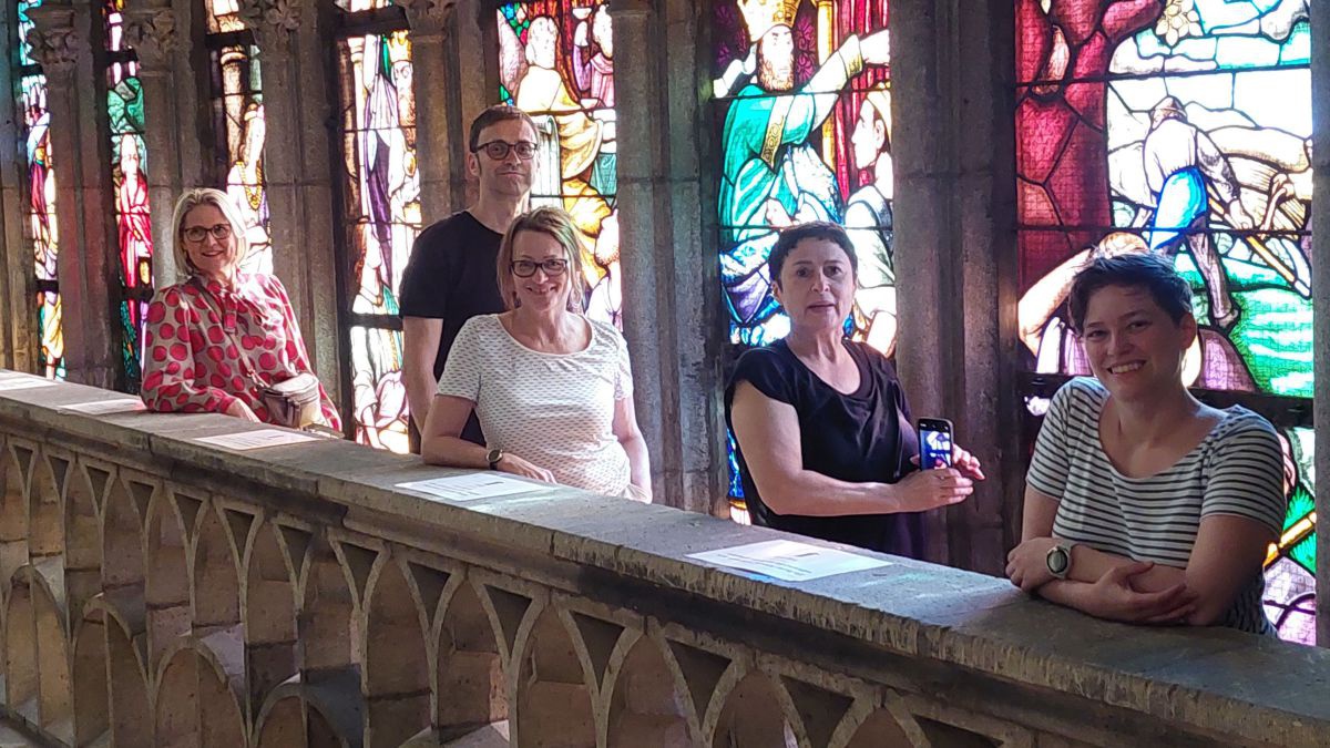 Besuchergruppe am Balkon im inneren der Kirche vei den Glasfenstern.