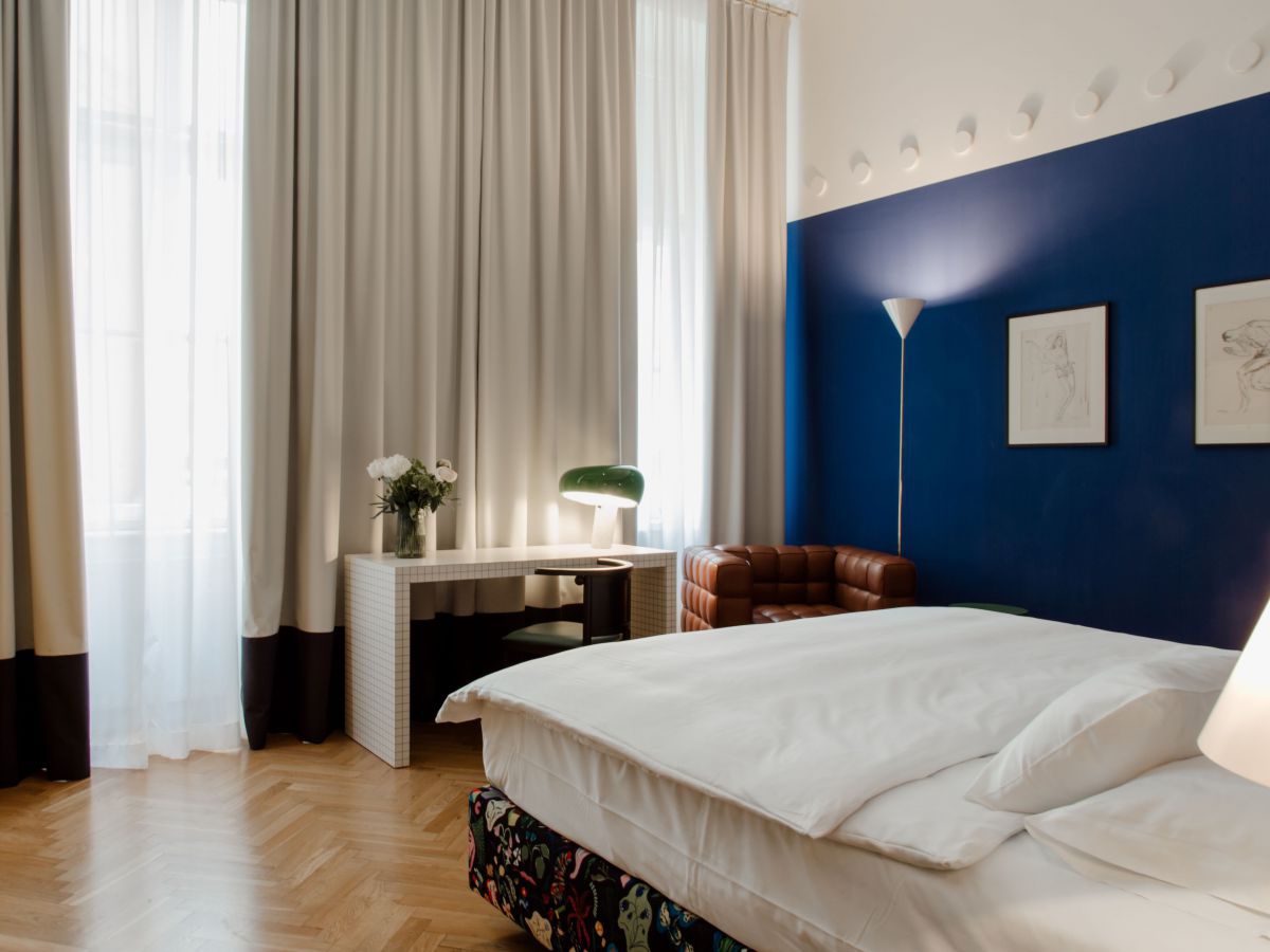Zimmer mit Doppelbett und blauer Wand.