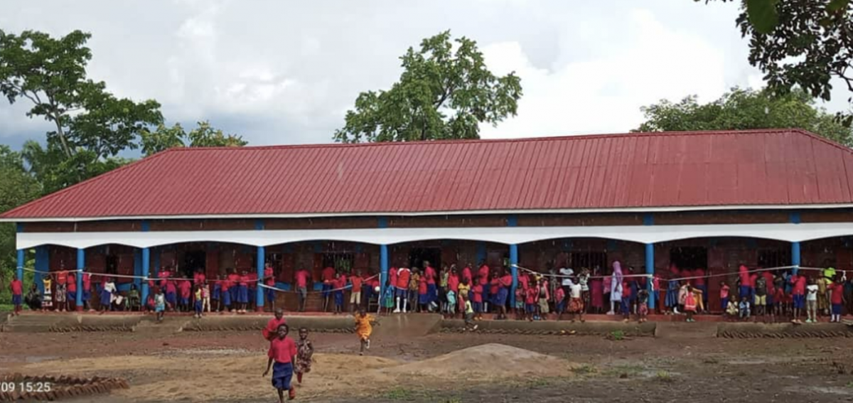 Viele Kinder vor einem Schulgebäude in Afrika.