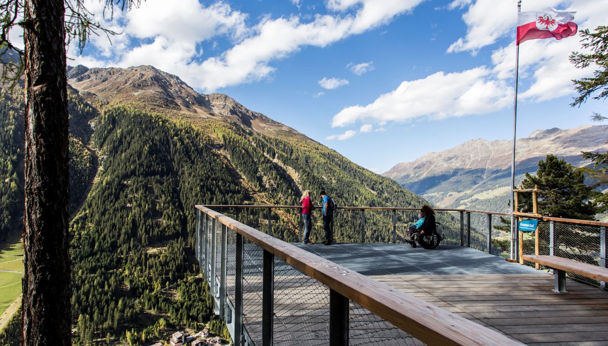 Plattform mit Blick ins Tal, darauf 3 Personen, eine im Rollstuhl.