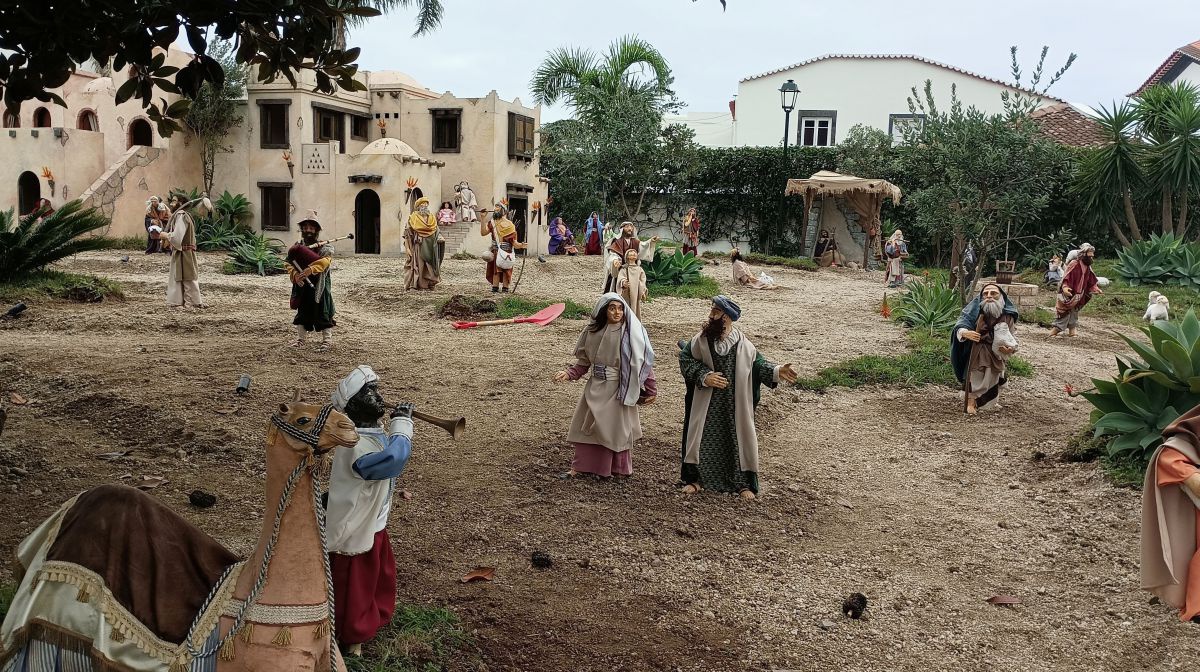 Weihnachtskrippe die aussieht wie ein Dorf, in dem Menschen miteinader plaudern, musizieren - ihrem Alltag nachgeghen.