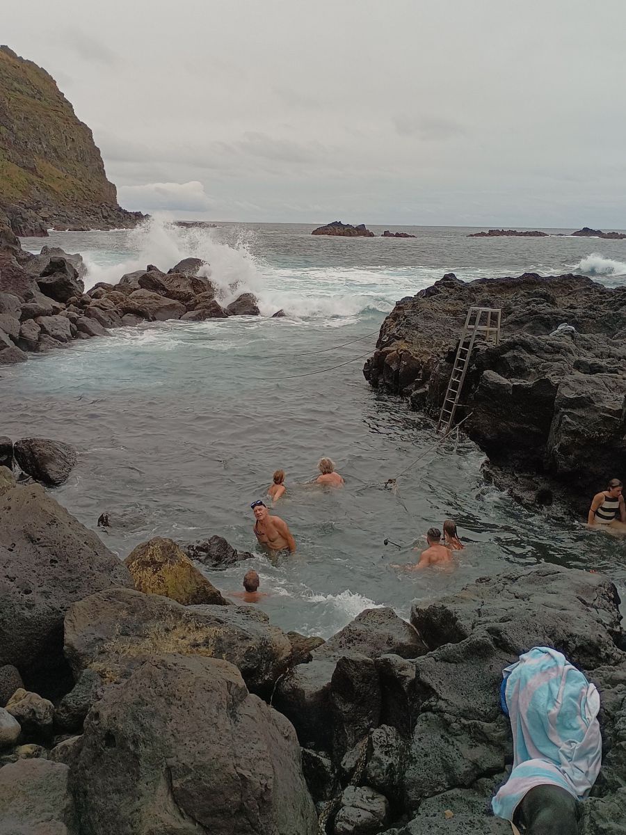 Eine Metallleiter füher in ein felsiges Becken im Meer, darin sind Seile gespannt, an denen man sich bei hohem Seegang anhalten sollte.
