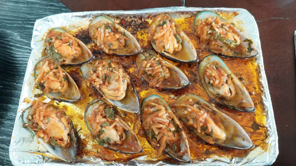 Muscheln mit Sauce rundherum auf Alufolie.