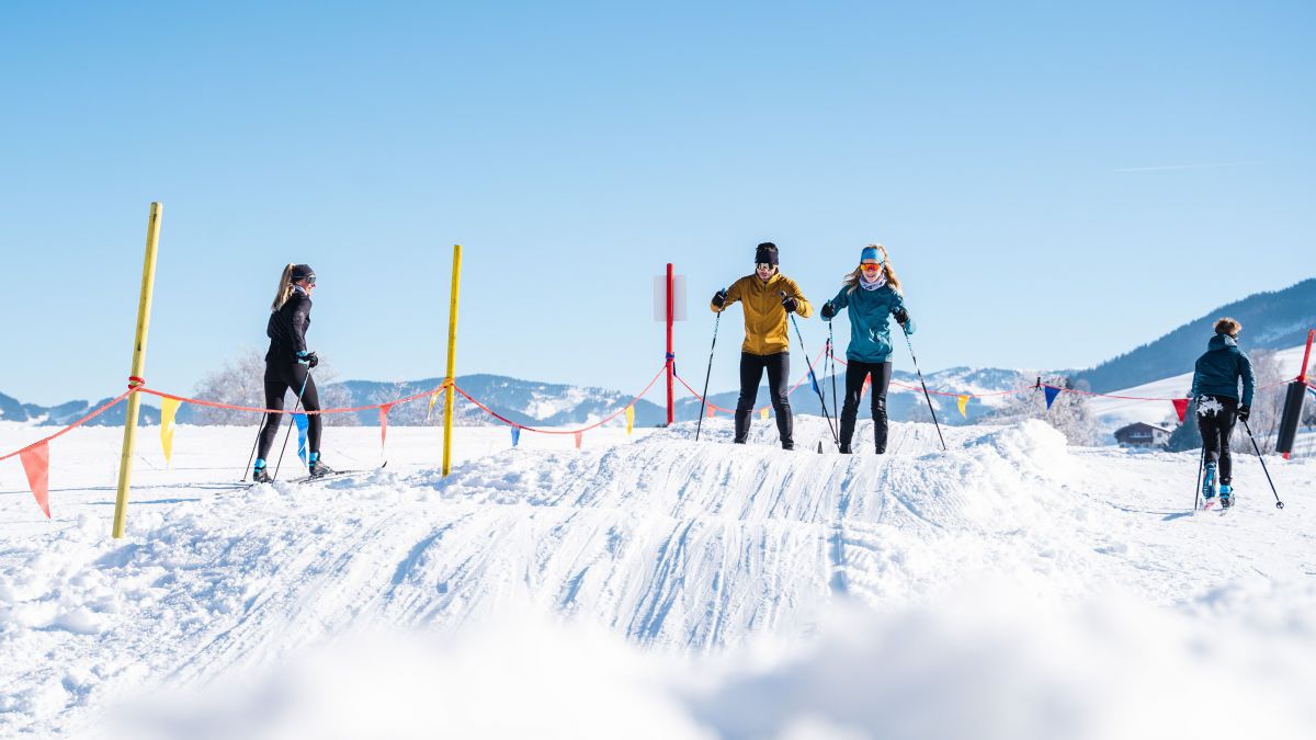 2 Langläufer üben auf einer welligen Piste.