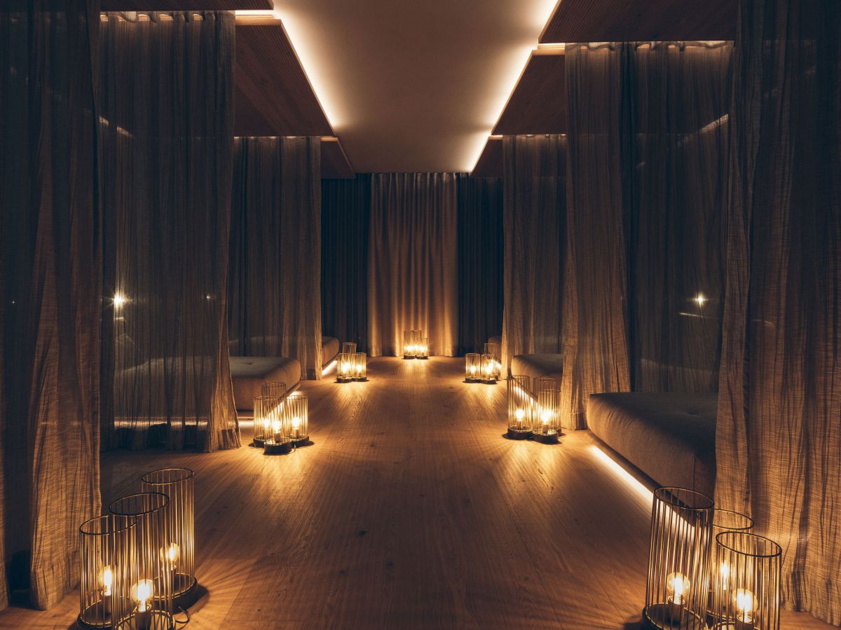 Ruheraum Matratzen mit Vorhönger rundherum, slles dunkel gehalten und stilvoll beleuchtet.