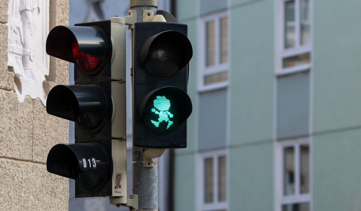 Bild zeigt eine Verkehrsampel in München: Bei der Fußgängerampel leuchtet statt der üblichen Silhouette einer menschlichen Person die des Kobolds Pumuckl grün.