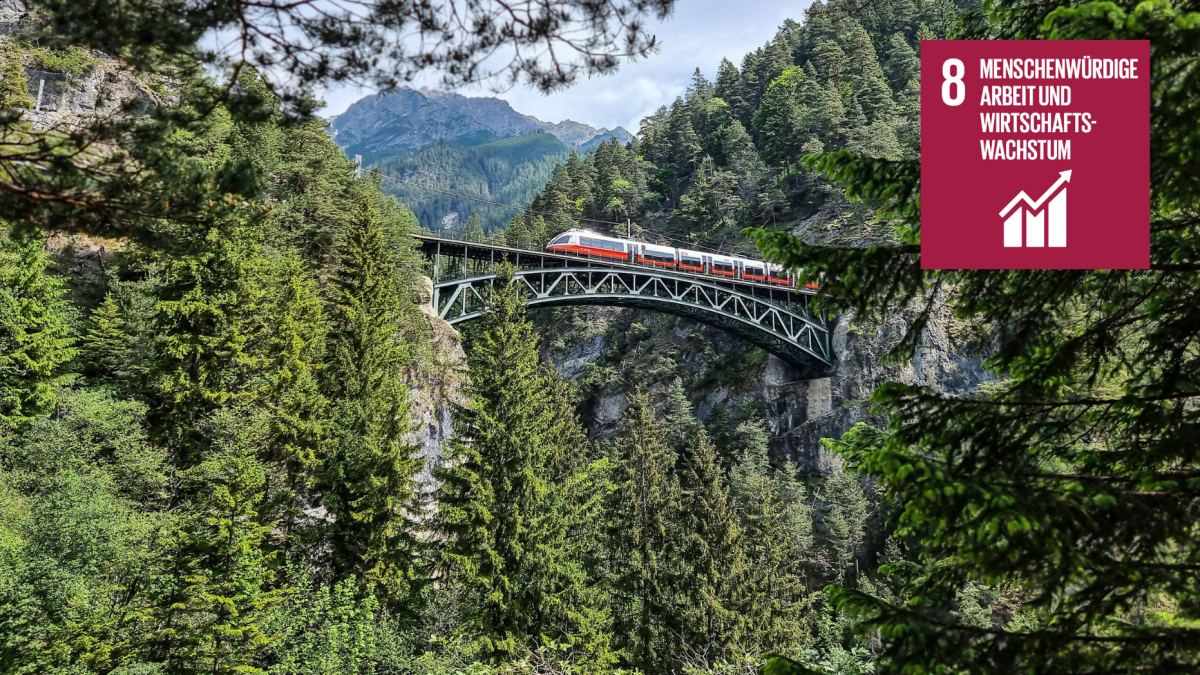 Zug fährt auf einer Stahlbrücke über eine Schlucht. Im Bild das Symbol des SDG 8 (rot mit Pfeilsymbol füt Wirtschaftswachstum).